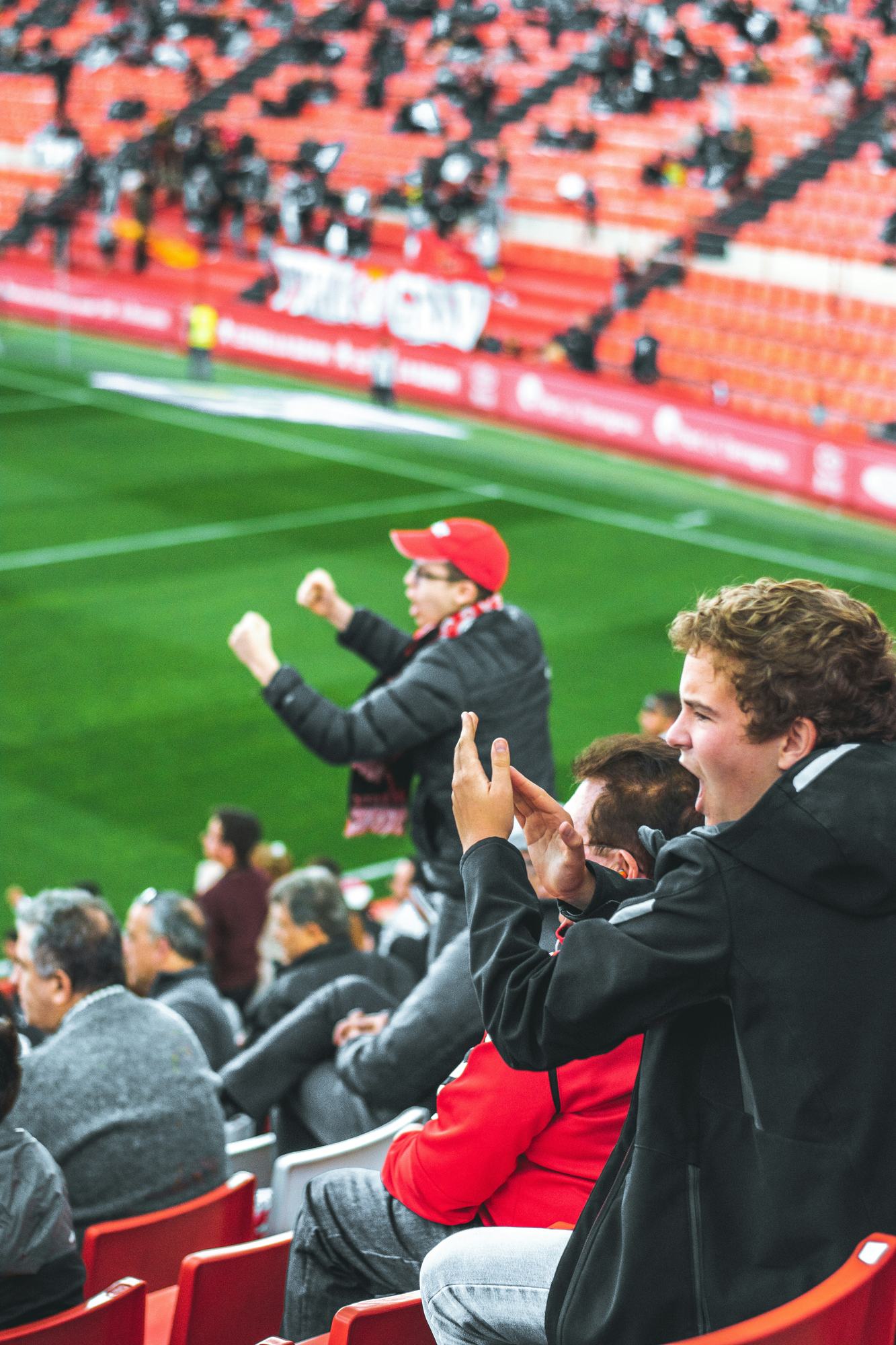 A young supporter cheering in the stand beside an older fan